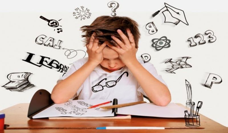 Menino com mão na cabeça preocupado pois não consegue enxergar e estudar